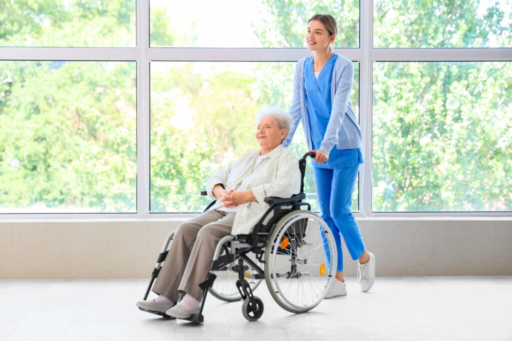 Nursing home staff wheeling a resident in a wheelchair.